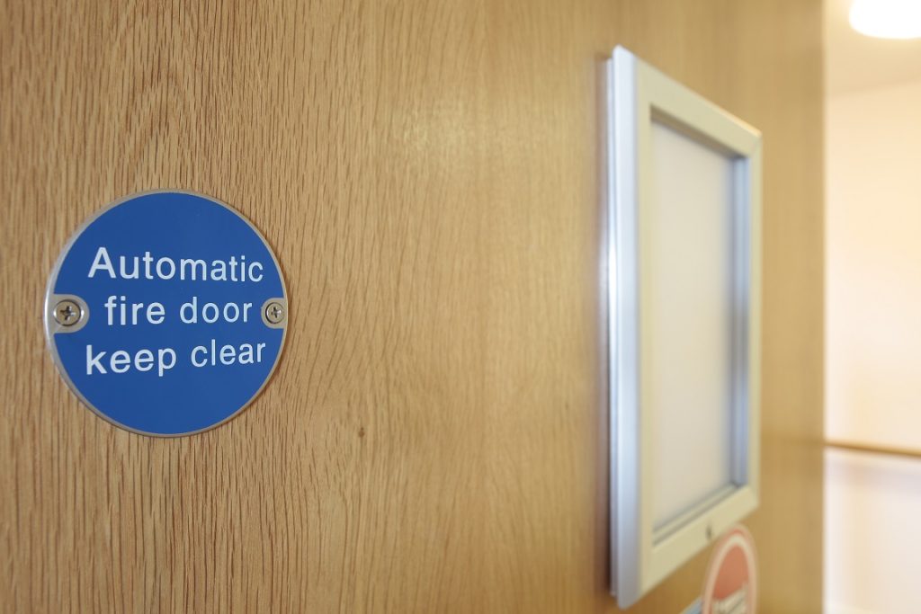 Illustration of a University Totem sign. Automatic Fire Door Keep Clear. Fire Safety