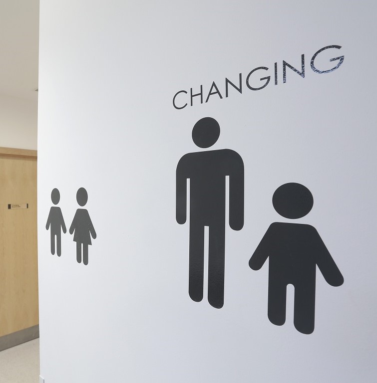 Sign design, toilet symbols, cut vinyl, male and female symbols, applied to an internal painted wall outside toilets