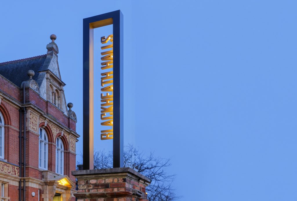 Blackheath Halls Built Up Illuminated text in totem frame at dusk
