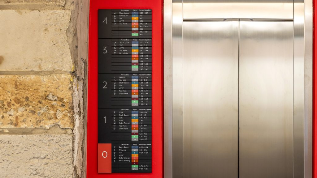 Edinburgh Futures Institute modular signage, directory sign fitted to a red wall next to a lift