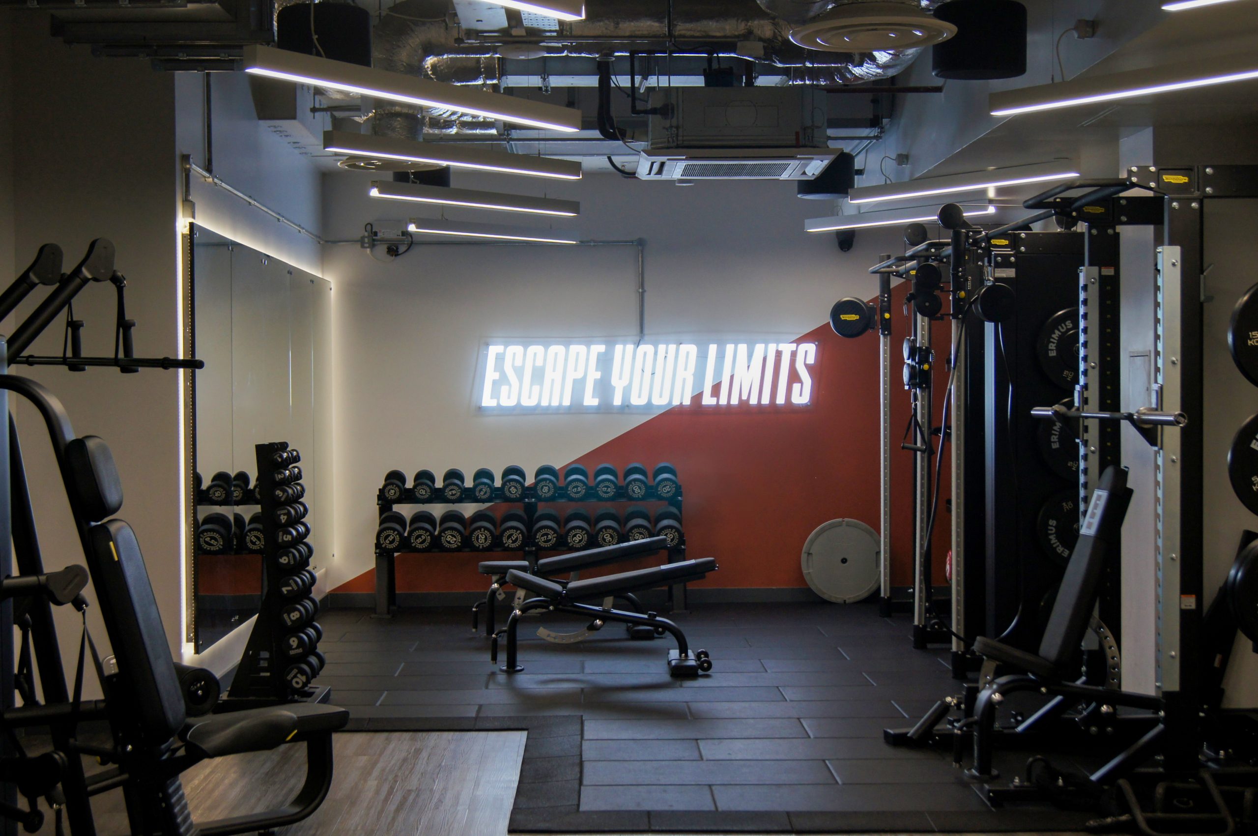 Neon signage in gym that reads escape your limits at Leeds Technology Campus.