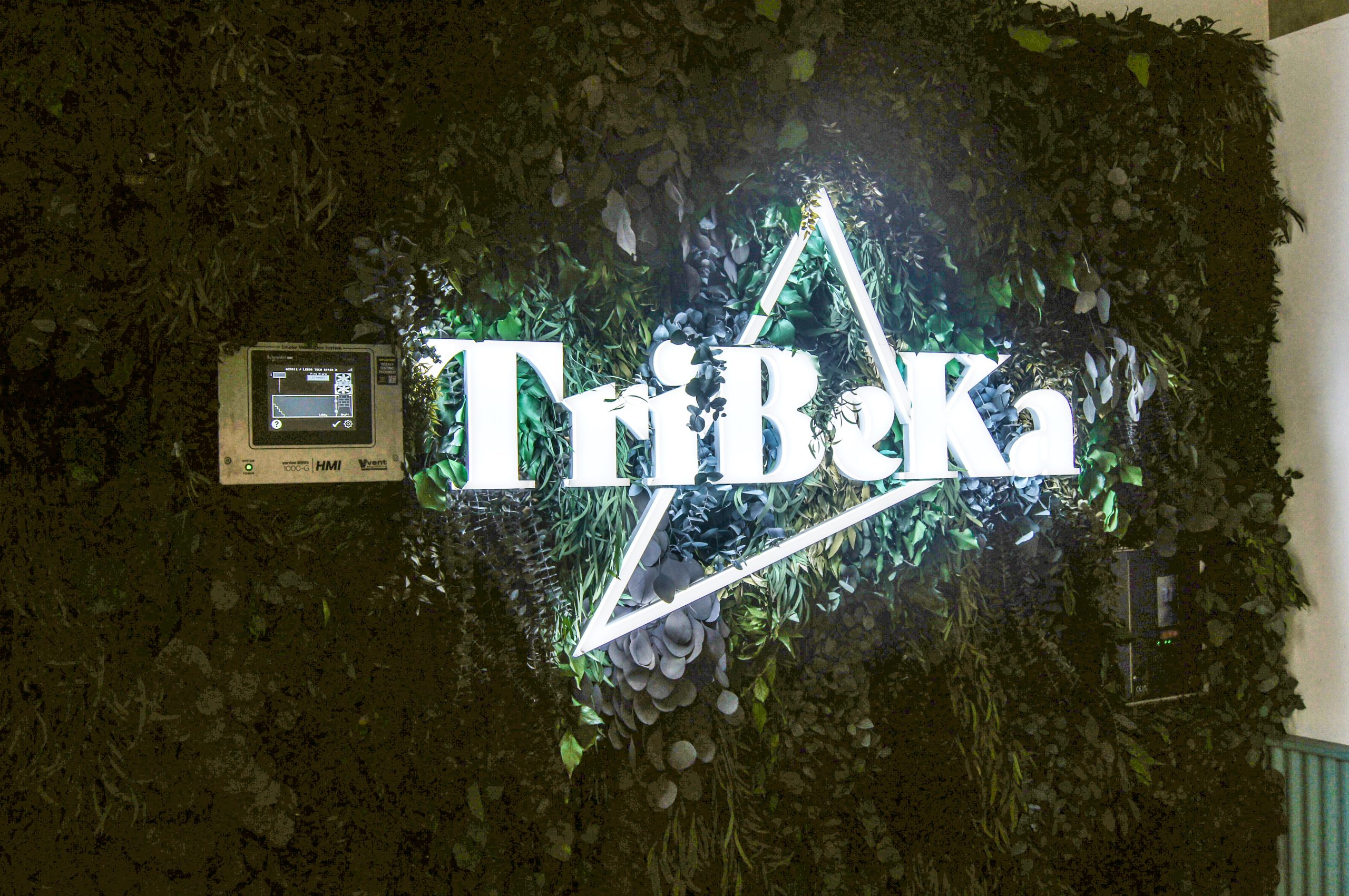 Face illuminated sign that reads Tribeka with a triangular shape around it at Leeds Technology Campus.