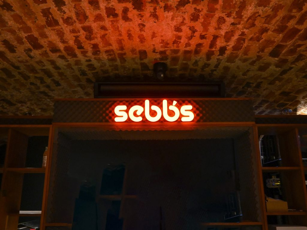 Sebbs illuminated sign above DJ Booth on lower level