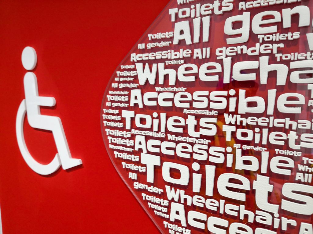 Golden Jubilee Hospital tactile text on an arrow with a disabled symbol directing towards an accessible toilet
