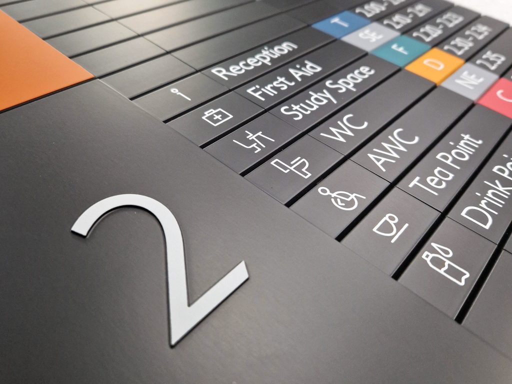 MSS Tactile Directory . Tactile white numeral 2 on a black directory panel with individual slats showing text and symbols for each floor