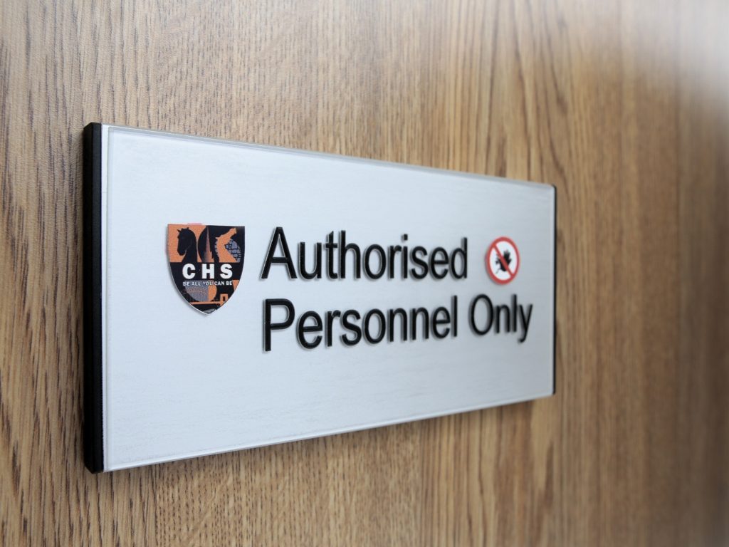 Tactile door sign with school logo and black text reading Authorised personnel only