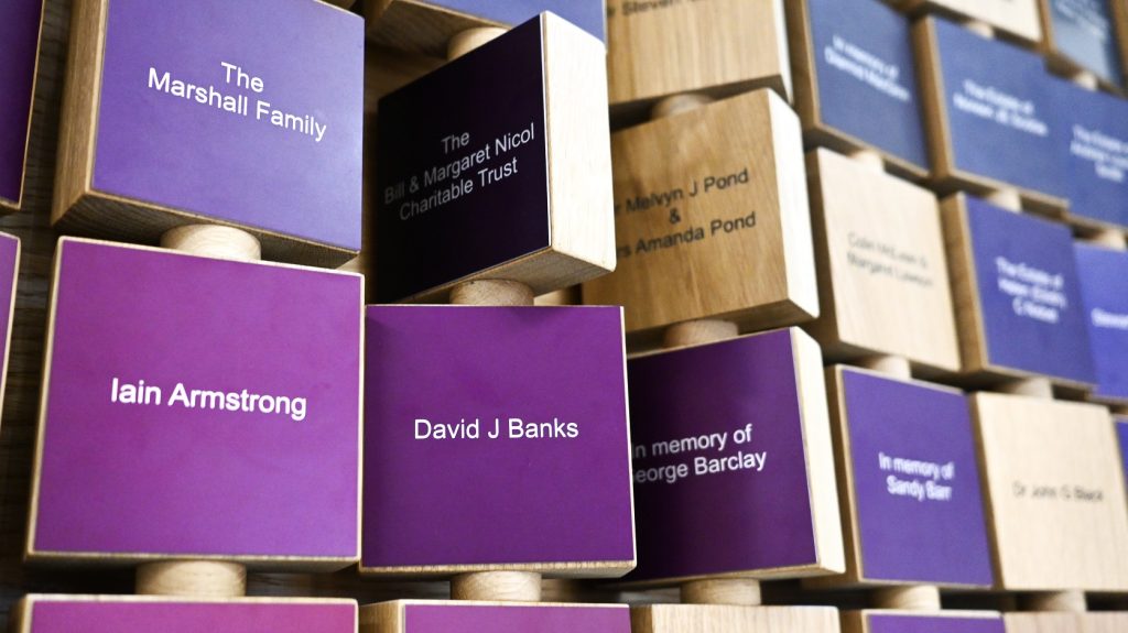 University of Glasgow ARC Building Donor Wall Engraved oak panels with shades of purple aluminium plates on one side. Sustainability in signage example