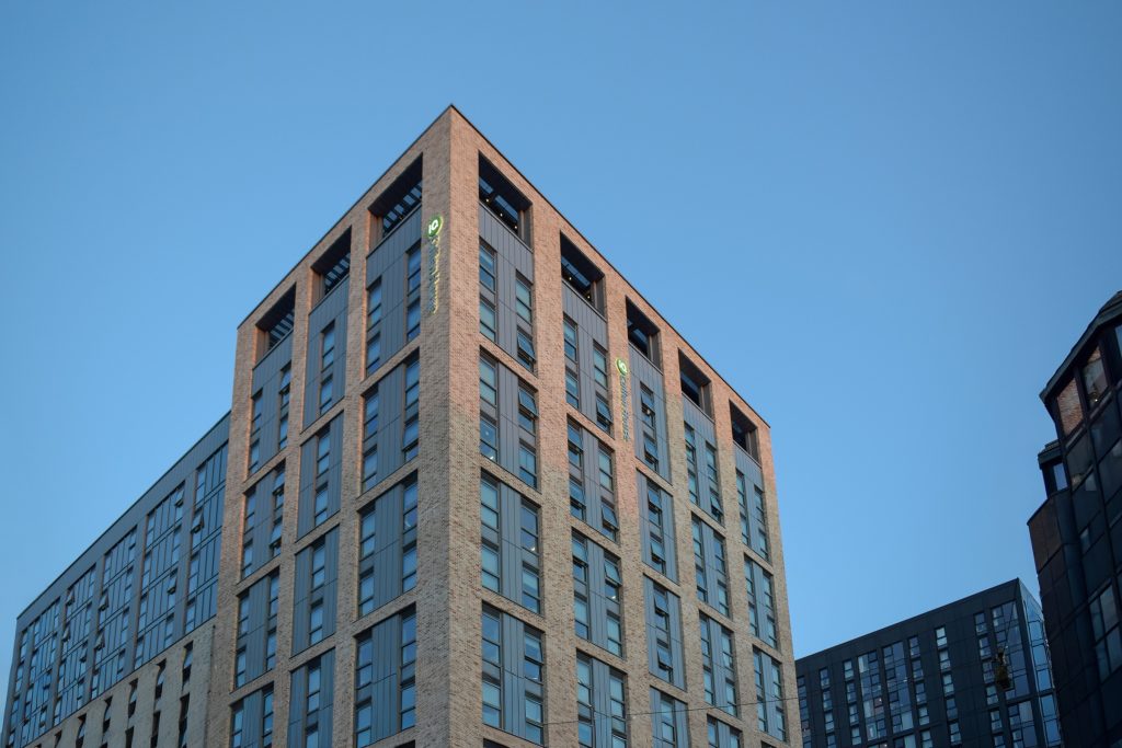 high level external building mounted illuminated text and logo on two sides of Cullen House building