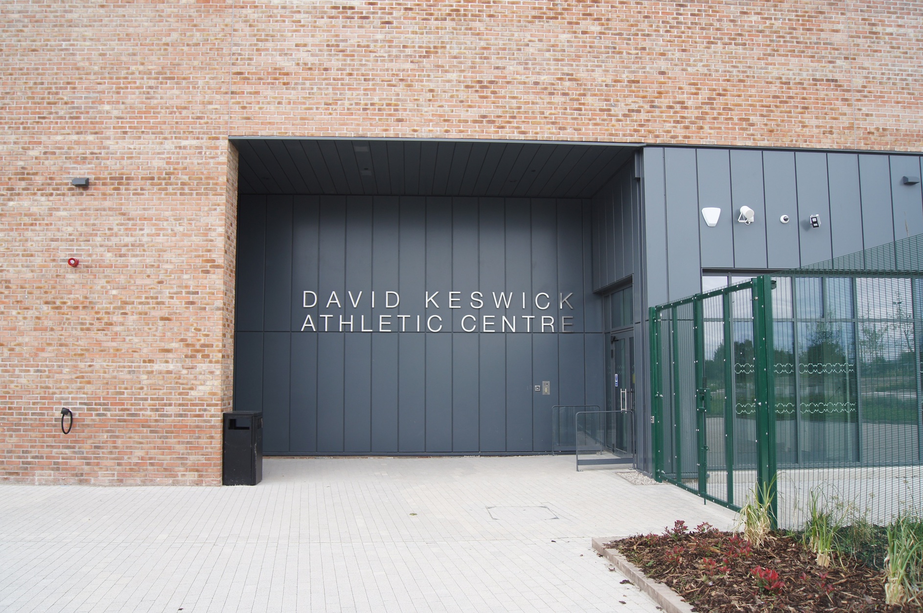 Dumfries High School Built up stainless steel text that reads DAVID KESWICK ATHLETIC CENTRE fitted to grey cladding